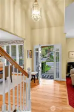 Entry interior. Dramatic, soaring ceiling with Traditional-style polished-brass-beveled-glass entry chandelier. Beautiful oak-hardwood floor. Elegant, atypical staircase with Traditional balustrade, oak-hardwood treads, formal painted risers.