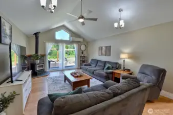 Living room with vaulted ceilings, lots of light and a wood stove to keep cozy during the winter.