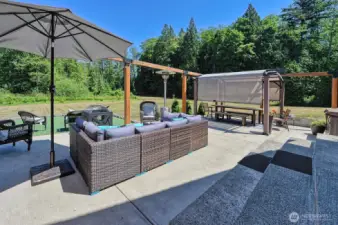 The back patio with a view of the backyard gently sloping down to the woods.