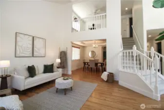 Impressive two-story foyer creates a grand entrance with soaring ceilings, elegant staircase, and open flow to both living and dining areas.