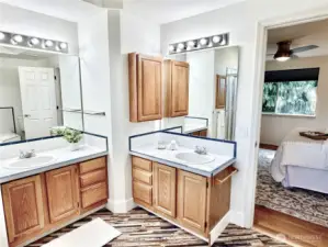 Master suite vanity area with dual sinks, ample oak cabinetry storage, and Hollywood-style lighting - your own personal spa space.