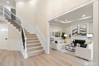 Dramatic foyer with soaring ceilings, statement staircase, and open sightlines into formal living spaces.