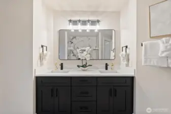Double-sink vanity with modern lighting and quartz counters.