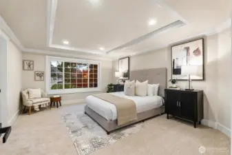 Expansive primary suite with tray ceilings and serene backyard views.