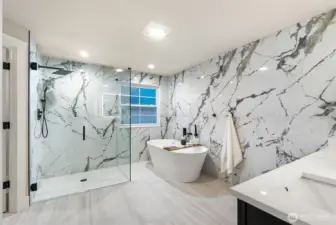 Luxury primary bathroom with freestanding soaking tub and full marble surround.