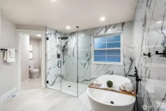 Walk-in glass shower with designer tile and frameless enclosure.