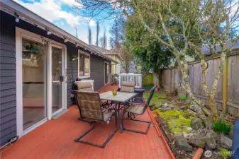 Fenced backyard and deck span between the kitchen and primary bedroom.