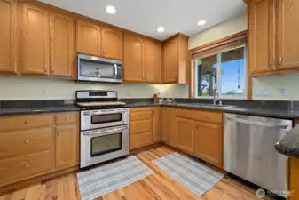 Grand kitchen w/sealed granite counter tops, pristine hardwood floors & stainless steel appliances that are all included.