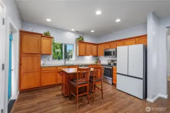 Kitchen with plenty of storage, new refrigerator and moveable kitchen island.