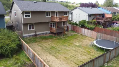 Spacious backyard with trampoline.