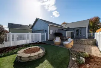 The dining area is filled with natural light and offers direct access to the private, fenced backyard — complete with a turf gathering space, seating area, and room to unwind or soak in the hot tub.