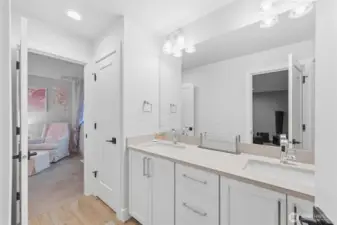 This ensuite bath is shared by a bedroom and the upper-level bonus room. To the left of the sink is a large linen closet.