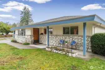 Covered front porch with stone detailing and sturdy columns offers a comfortable place to sit and enjoy the neighborhood. Large front windows and a warm wood entry door add character and visual interest.