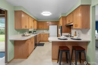 Galley-style design offers efficient workflow with long stretches of countertop and cabinet space on both sides. A nearby exterior door provides quick access to the backyard.