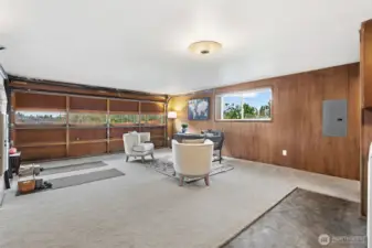 Spacious rec room offers flexible space for a lounge, home office, or workout area. Large window brings in natural light while the wide garage door provides convenient access and added versatility.