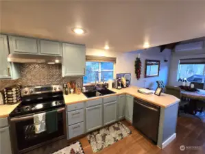 Nicely appointed kitchen has a good amount of counter space and an L-shaped eating bar with stools on the back side.