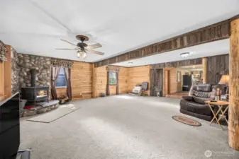 River rock fireplace surrounds the free standing stove in the large family room. Located just between the front door & side porch door that opens into the kitchen.