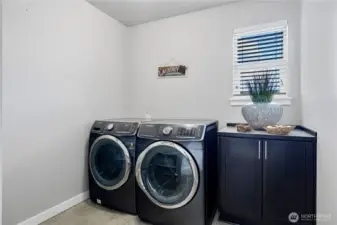 Laundry room with shelfs and ample space for ironing board