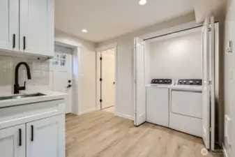 Lower level is an excellent potential for a mother-in-law suite, complete with a kitchenette, two bedrooms, a full bath, a laundry area, and a private entrance.