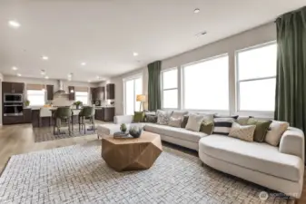 Open concept great room, informal dining area, breakfast bar, and large windows pouring in natural light. Photo is representational. Actual home is under construction and finishes will vary. See site agent for details.