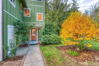 Golden foliage adds a warm, welcoming touch to the entry. The utility closet on the left contains the hot water heater, well filtration system, and pressure tank.
