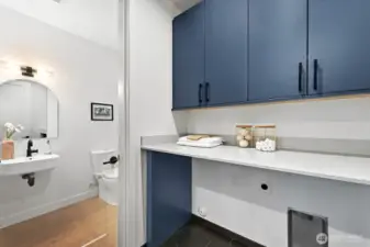Side-by-side laundry room with additional storage + access to powder room.