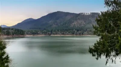 A setting that feels tucked away, yet wide open with the beautiful colorful waters of Alder Lake taking center stage