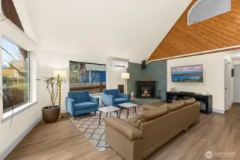 Living room with updated Luxury Vinyl Plank flooring, new tiled fireplace corner complete with electric fireplace. LARGE amounts of natural light from all the windows.