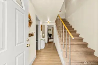 Walk through front door into the house - carpeted stairway up to the primary suite with the laundry room off to the right before you head up. Kitchen entrance first up down the hallway, then living room and main floor bedroom at end of hallway. Main floor bathroom located at end of hallway off to the right at back edge of staircase. New Luxury Vinyl Plank floors down the entrance hallway into kitchen and living room.