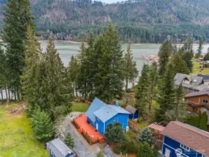 Aerial glimpse of life at Alder Lake House - huge wrap around deck at main house, gravel driveway, detached garage/shop with carport and a 2bd, 2ba DADU featuring an upper deck with a lake view for your guests, extra outbuildings for storage, and .7 acres of property to play, live and enjoy lake life.