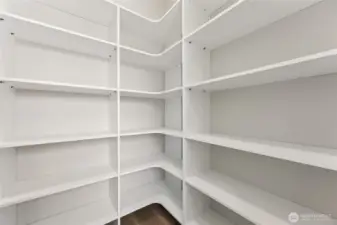 Custom-built pantry with wraparound shelving offers generous, well-organized storage—perfect for keeping staples, snacks, and kitchen essentials neatly tucked away and easily accessible.