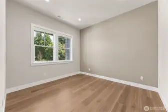 Versatile main-level bedroom with a large window and neutral palette—perfect for guests or a home office.