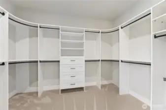 The spacious walk-in closet offers built-in shelving, drawers, and multiple hanging areas, providing both function and flexibility for organized storage.