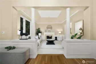 A columned architectural opening creates a striking visual entry into the formal living room