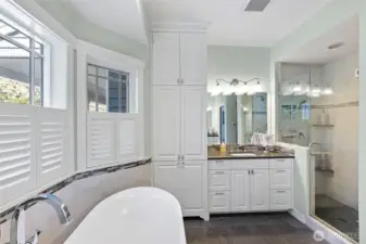 Primary bathroom features two separate vanities and a walk-in shower
