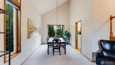 The large and open dining room has a soaring ceiling and wonderful view into the backyard.