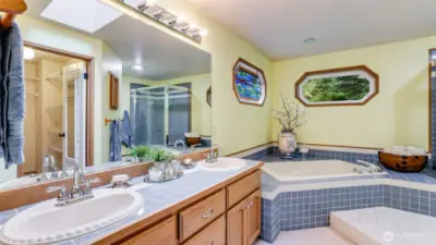 The primary bath is a 5-piece bath with 2 sinks, soaking tub, separate shower and walk-in closet. area.  The counter is tile along with the flooring and the bath and shower surround.