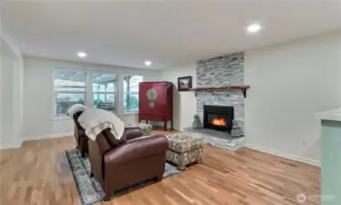 View of the massive living room from entry, LOVE these hardwood floors and fireplace, plus larger windows and LED lighting.