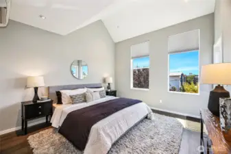 Primary bedroom with vaulted ceilings and recessed lighting. South facing windows for natural light.
