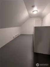 The space between upstairs bedrooms has space for a couch. There is a storage room at the top of the stairs.