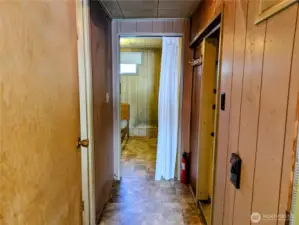 Hall from main bedroom into the house kitchen to the right, bathroom to the left