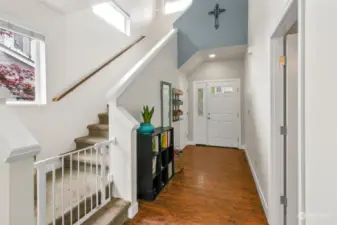 Looking at the entry from the living room with the stairs leading to the upper floor.