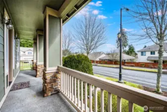 Enjoy morning coffee or evening relaxation on the spacious covered front porch, featuring two inviting sitting areas and charming stone-accented columns.