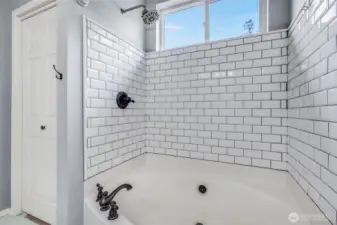 Relax and unwind in the luxurious soaking shower-tub combo, featuring a sleek tile surround and elegant fixtures for a spa-like retreat in the primary bathroom.