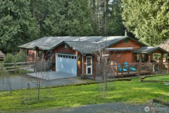 One-level home on 2.4 acres, featuring walking trails, a shop, a cabin, and outbuildings.