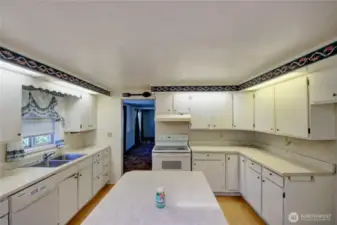 Bright, oversized kitchen with white cabinetry and plenty of counter space