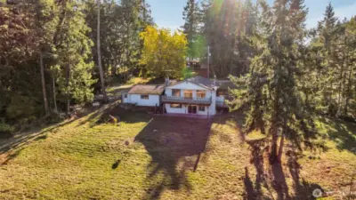 Expansive back yard surrounded by trees makes for a lovely retreat