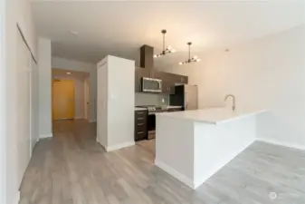 Large, refreshed open concept kitchen with slab countertop/eat-in bar.