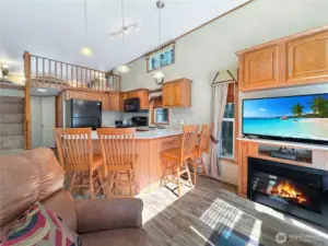 Open living space includes the kitchen with breakfast bar.