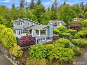 Beautifully landscaped with easy care bushes and tress this home sits almost at the end of a quiet cul-de-sac. The grey shingled structure to the right is part of the main home connected in the interior.